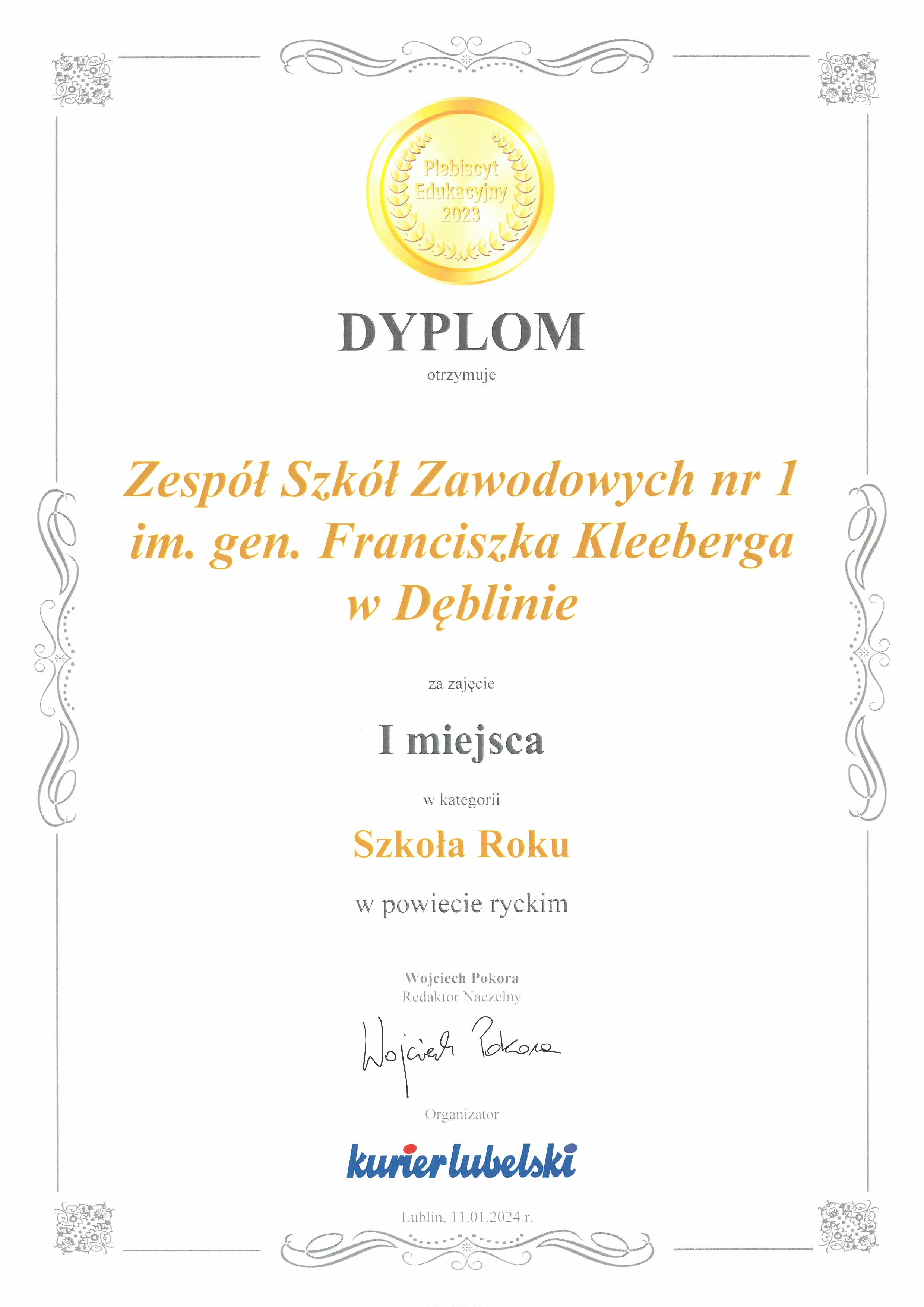 Zdjęcie dyplomu z złotymi zdobieniami, zawierającego tekst